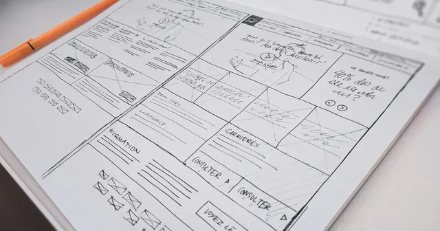 Hand-drawn website wireframe sketch on paper, planning a landing page or company profile layout