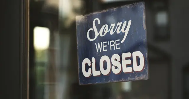 Sorry we're closed sign hanging on a shop door, like a website that turns customers away